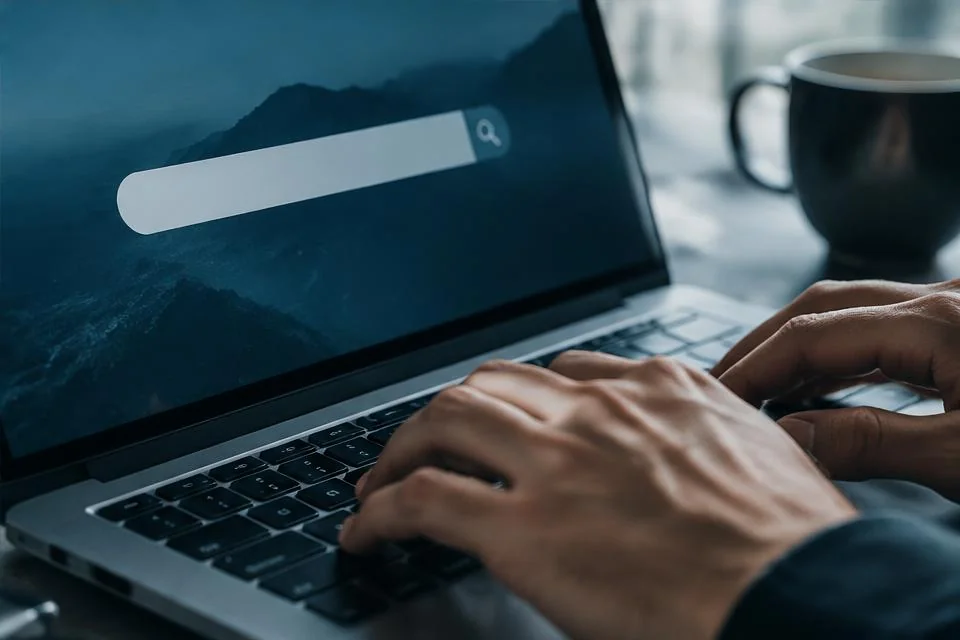 Person using a digital search field on a laptop